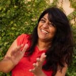 Vibrant woman smiling outdoors, professional headshot for personal branding, confident and approachable.