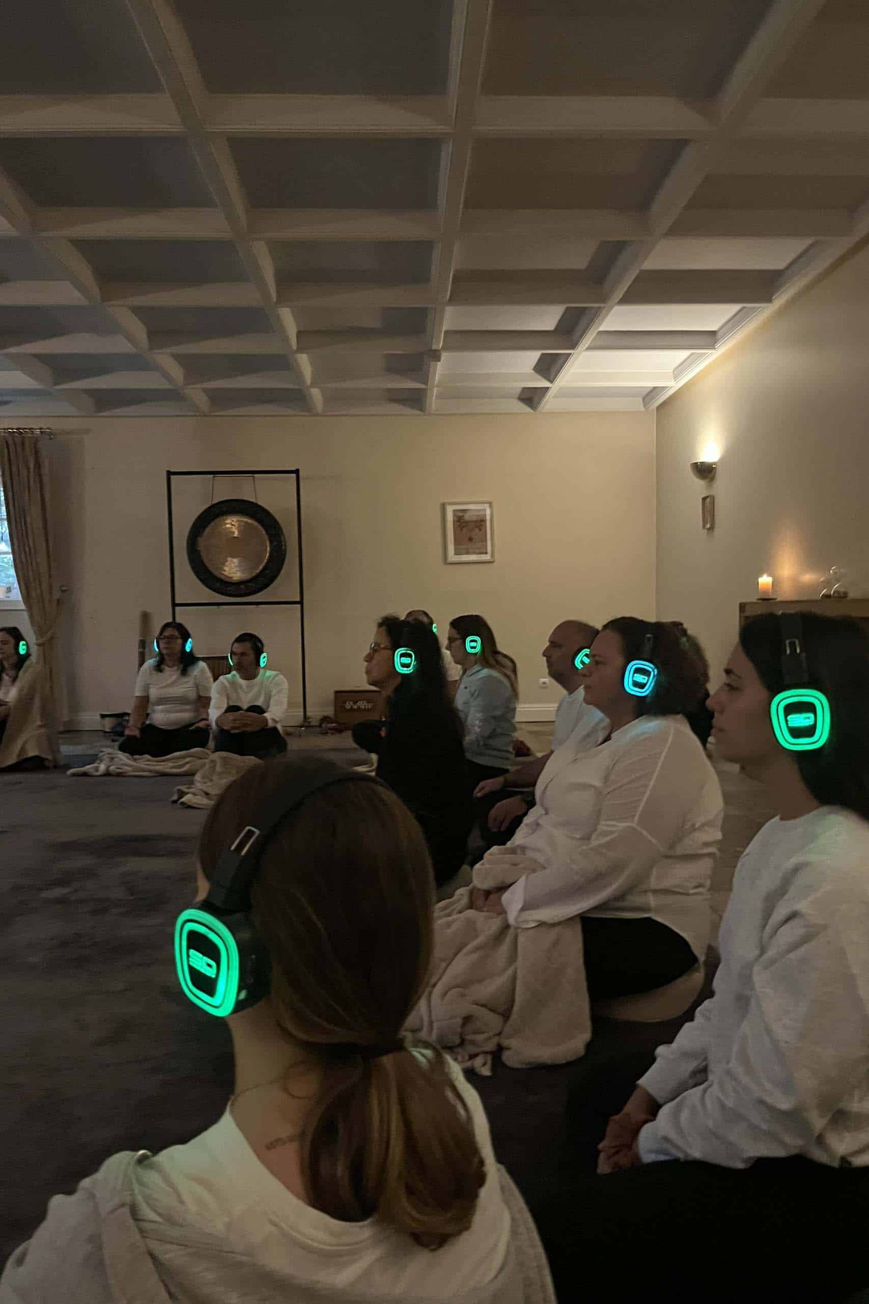 1. People meditating with wireless headphones in a cozy, dimly lit room for relaxation or mindfulness.