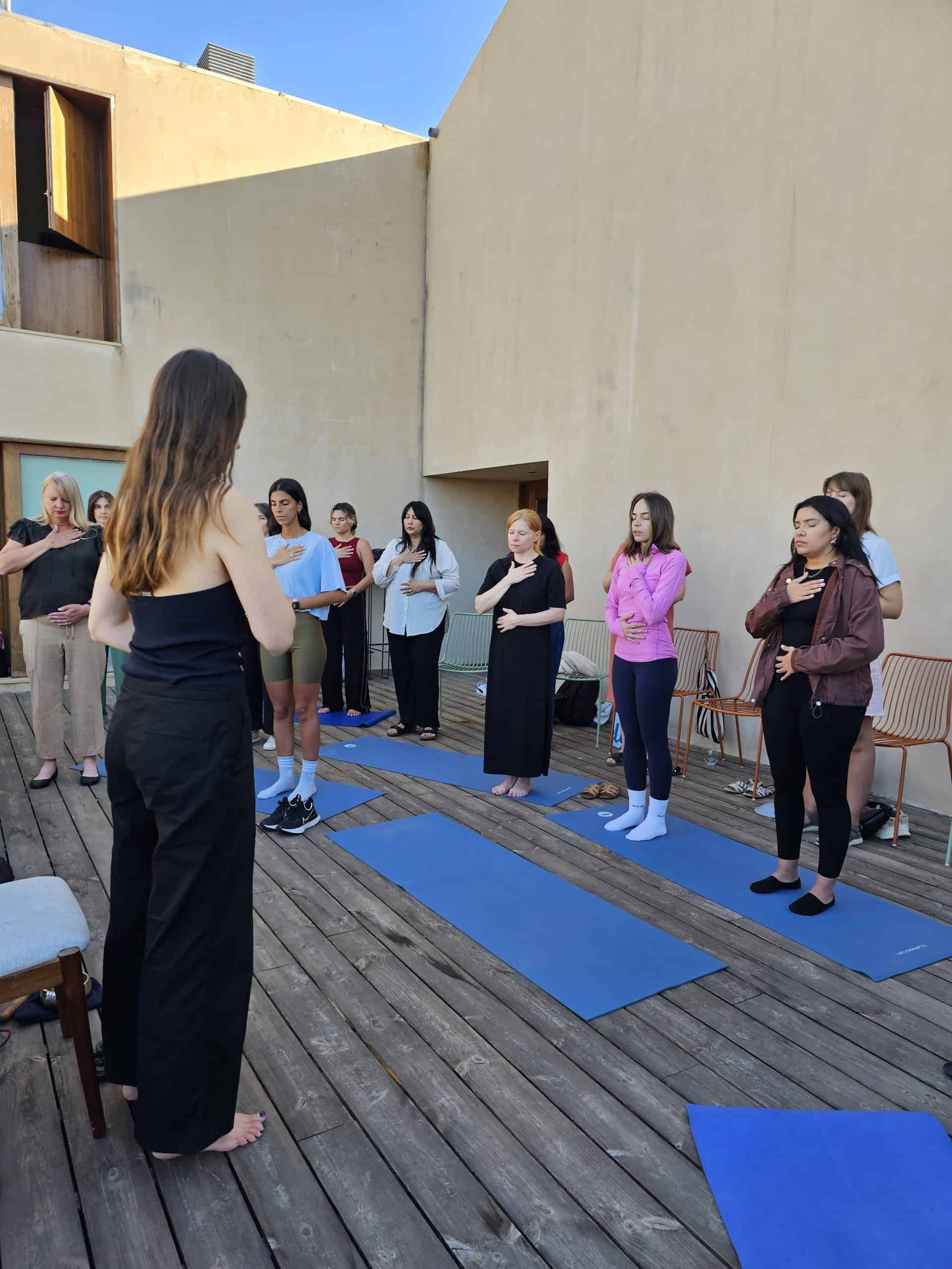 Relaxing outdoor yoga class with women practicing mindfulness and breathing exercises.